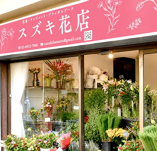 季節の花々が並ぶスズキ花店ブライダルファクトリーの外観